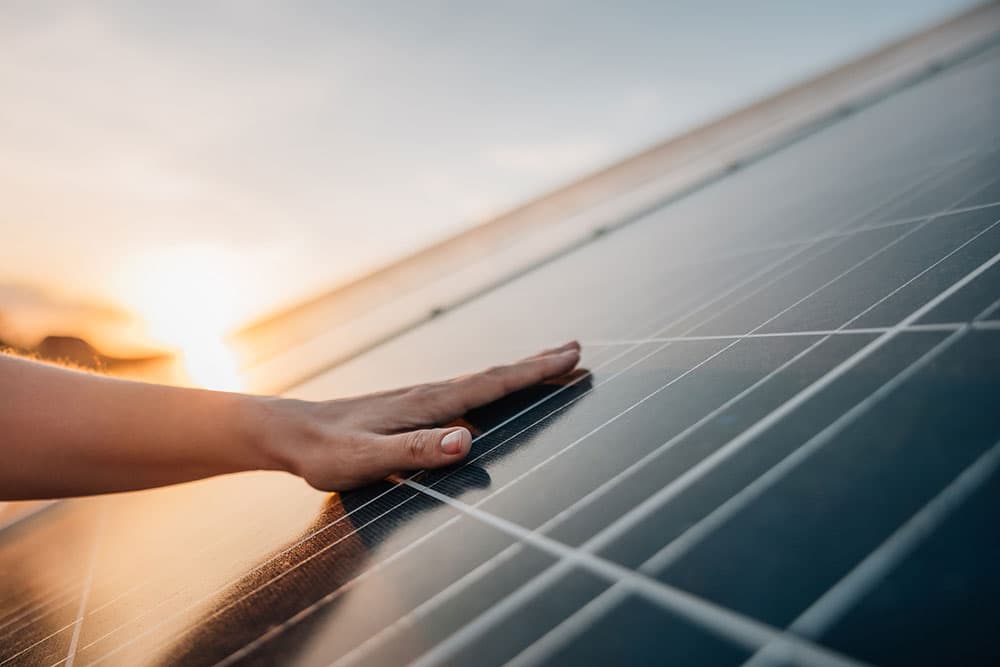 A hand resting on a solar panel